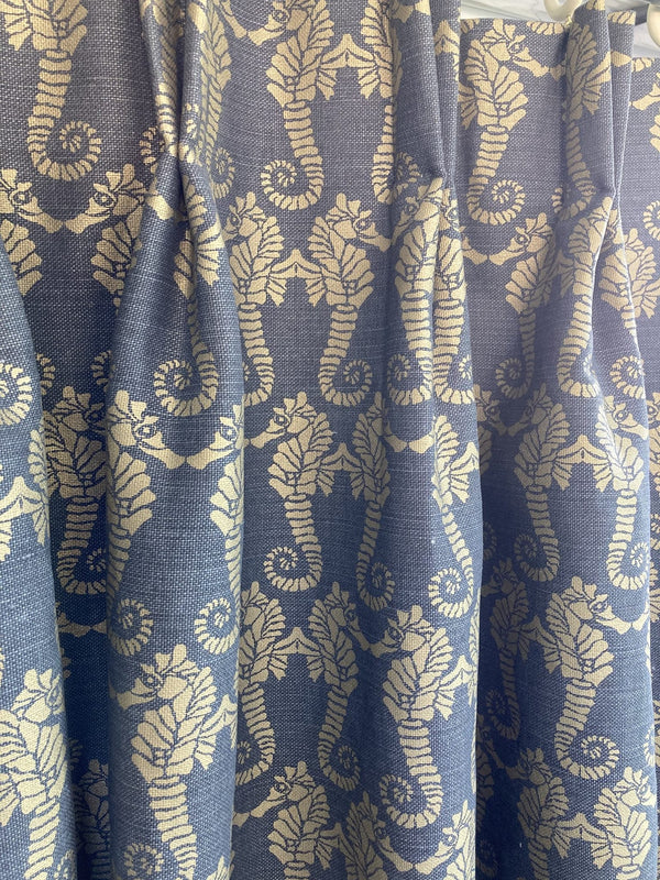 Roll of blue fabric with beige floral pattern