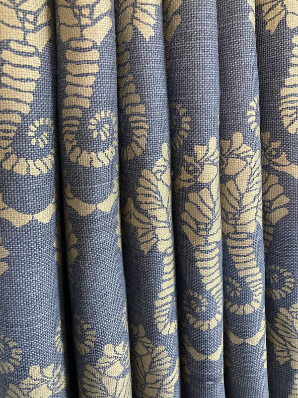 Stack of blue fabric with beige floral pattern